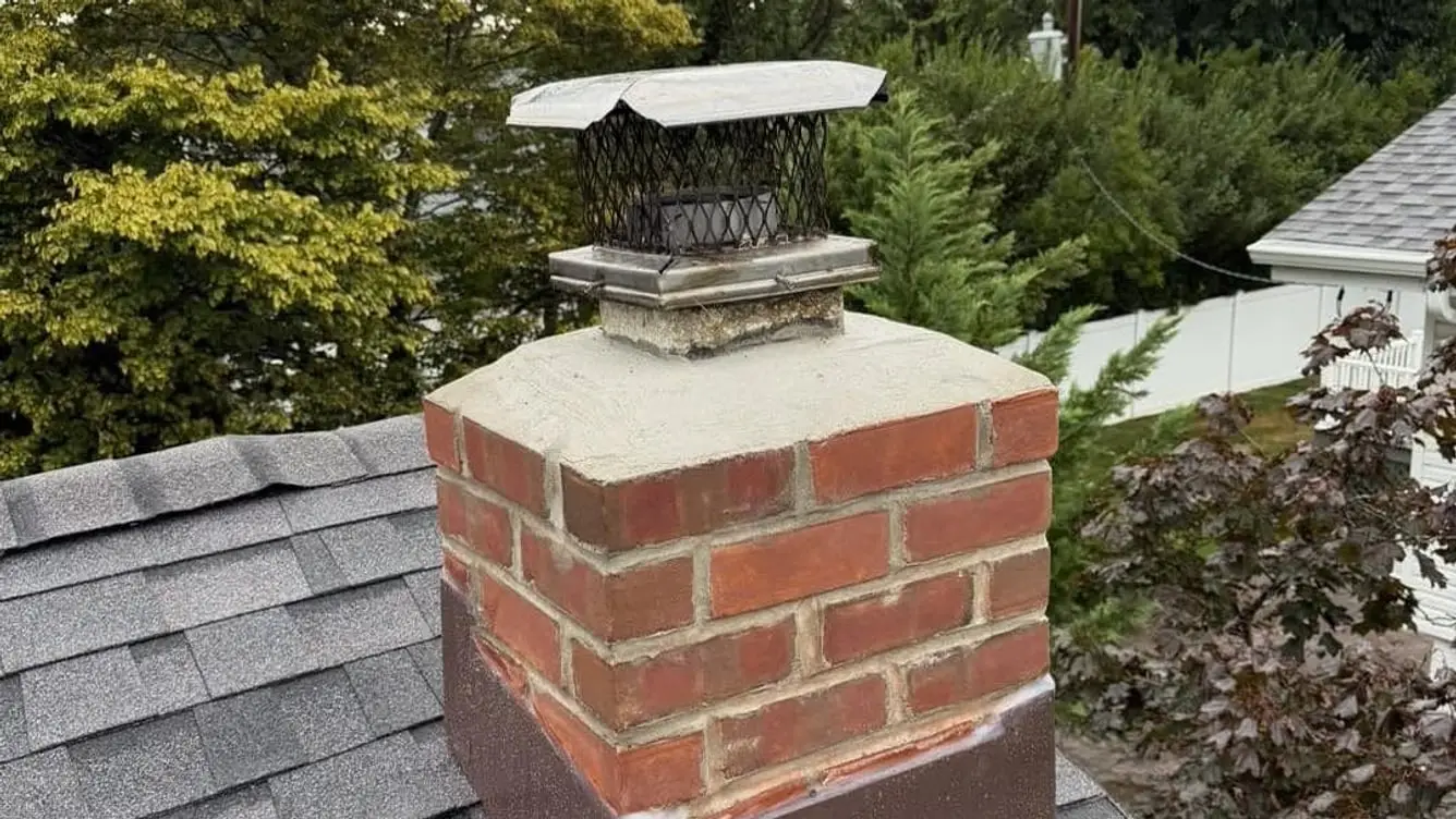 The rebuilt chimney with new brickwork, a fresh crown, a new cap and new base flashing